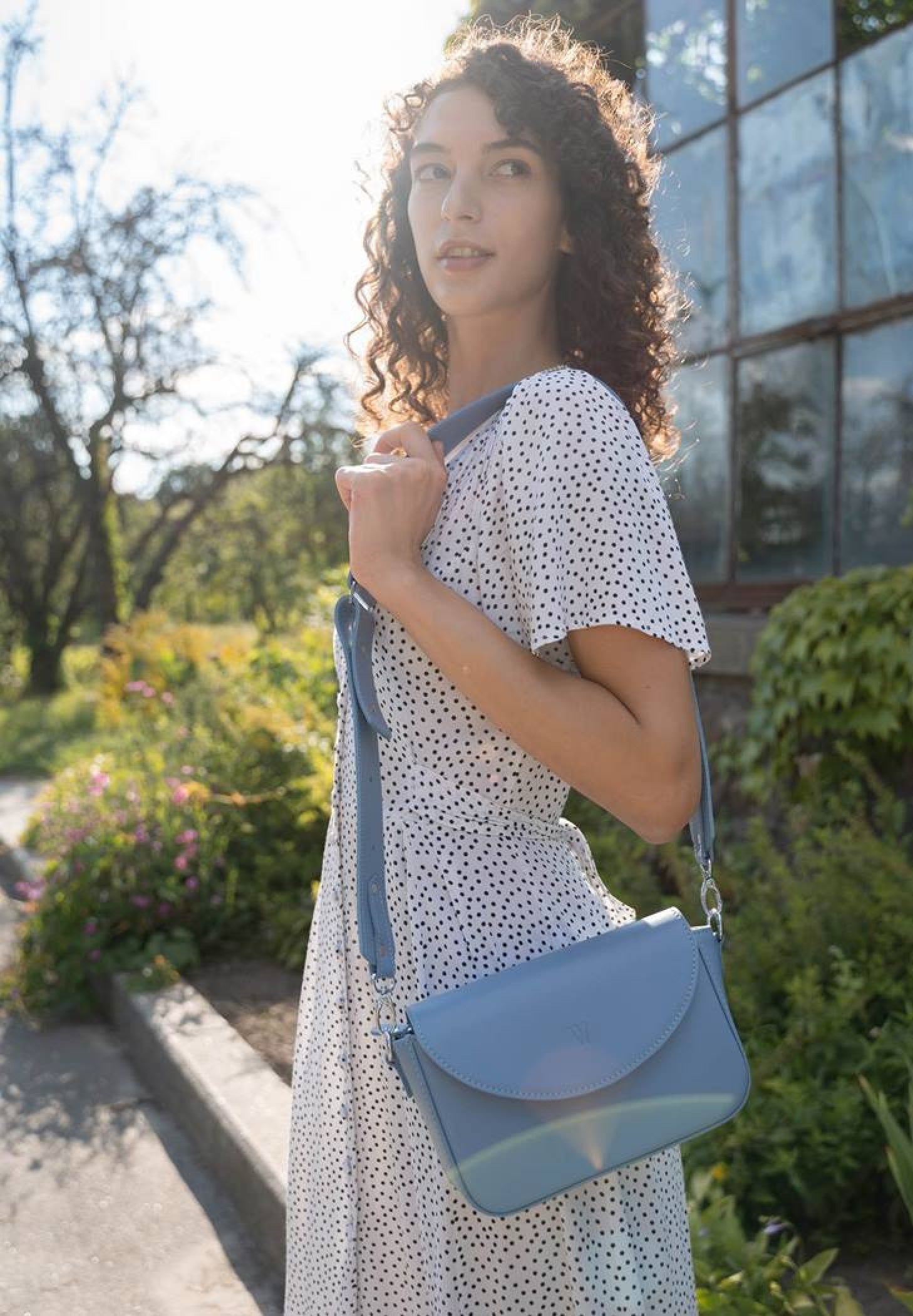 a beautiful young woman wearing a Molly leather bag for women in light blue color