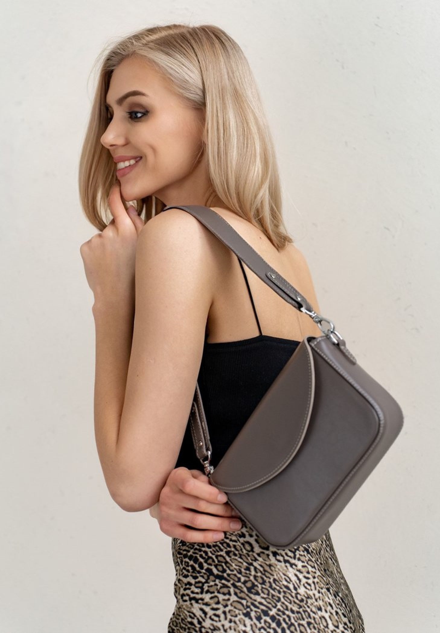 A beautiful blond hair woman wearing Molly leather bag for women in mokko color