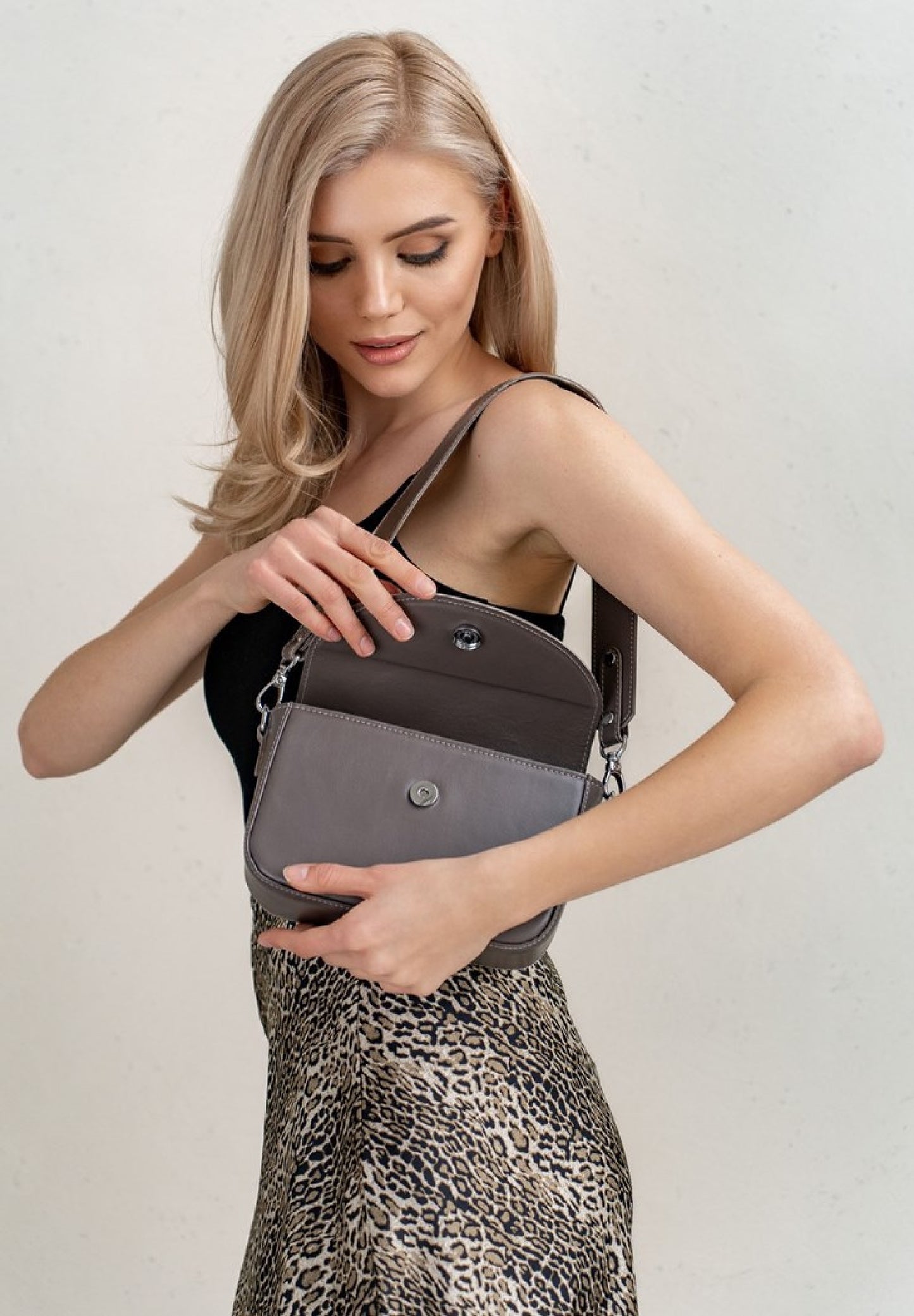 A beautiful blond hair woman wearing Molly leather bag for women in mokko color
